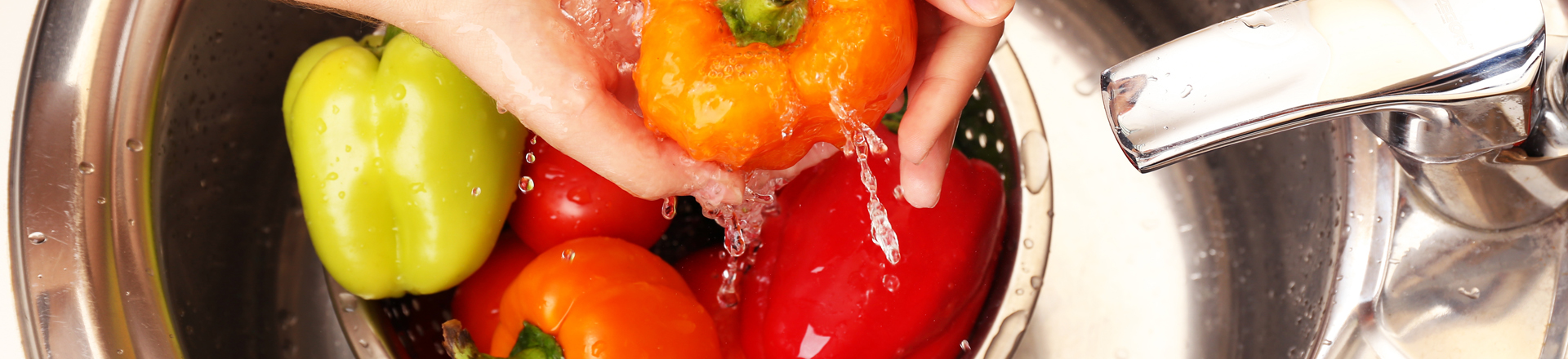 women washing bell peppers, which are on the Environmental Working Group's dirty dozen foods list because they have tested positive for higher pesticide residues.