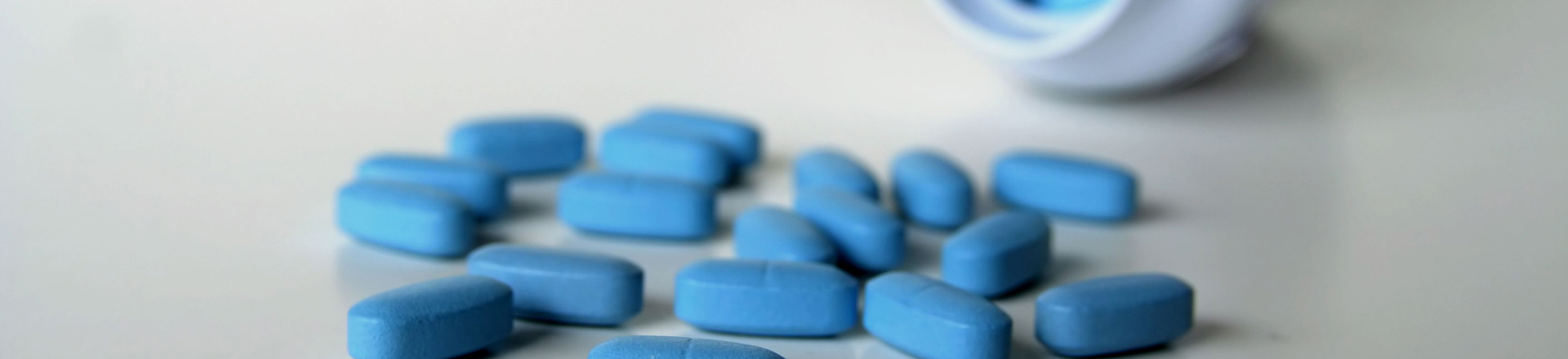 blue pills spread on a white counter