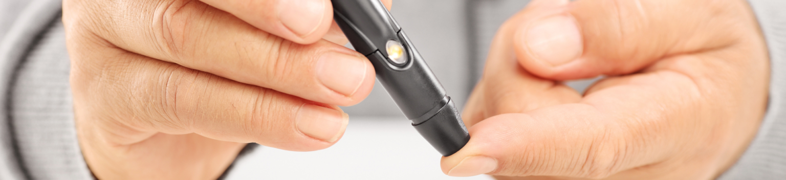 Close up of a mature diabetic patient measuring sugar level in blood using glucometer