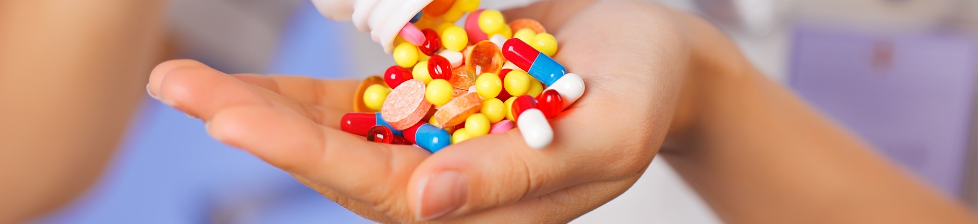 handfull of bright colored pills indicating too many medications and polypharmacy