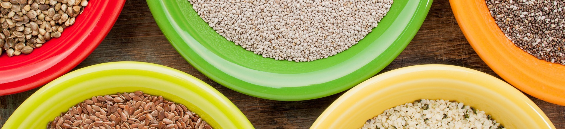 white and black chia, flax and hemp seeds in colorful ceramic bowls