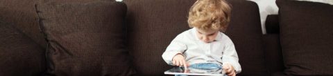 small boy with laptop on lap faces potential wifi dangers