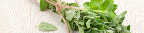 bunch of fresh oregano with health benefits on a wood cutting board